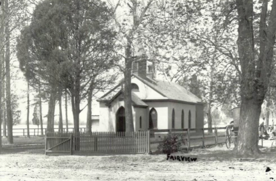 A Black and White Image of a House With a Fence